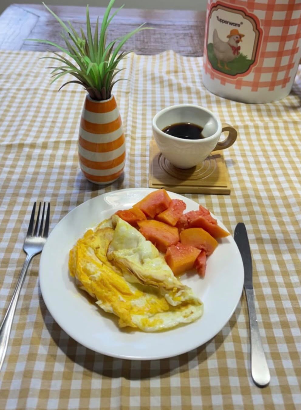 Omelete com mamão e café na mesa posta